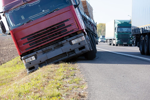 A semi-truck parking on the shoulder of the road with improper turns and no hazard lights, which often causes rear-end collisions.