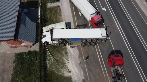 Trucking accidents can be caused by improperly secured truck cargo, like this accident where a truck overturned and nearly collided with another truck.